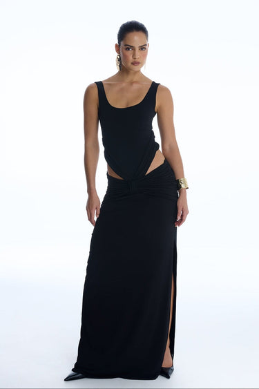 Woman wearing a black evening gown with cut-out design on a white background