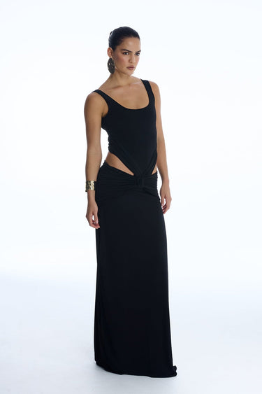 Woman wearing a black evening gown with cut-out design on a white background