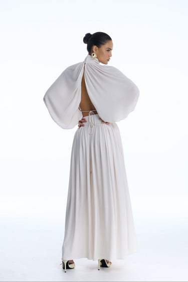 Woman wearing a white dress with a draped top on a white background