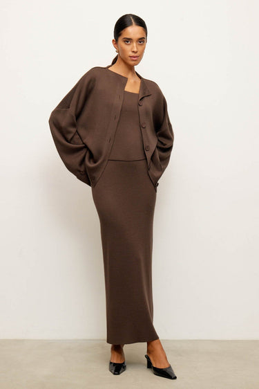 Woman wearing a brown outfit against a white background