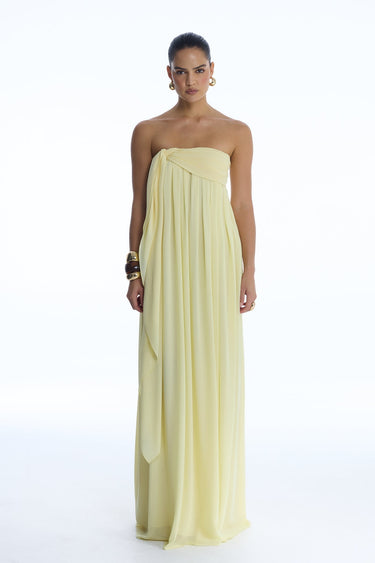 Woman wearing a light yellow strapless gown on a white background