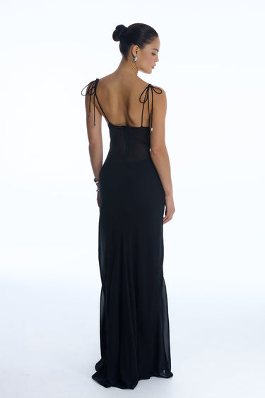 Woman wearing a black evening gown with open back on a white background