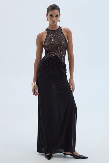 Woman wearing a black evening gown with lace top on a white background