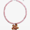 Pink beaded necklace with a floral pendant on a white background