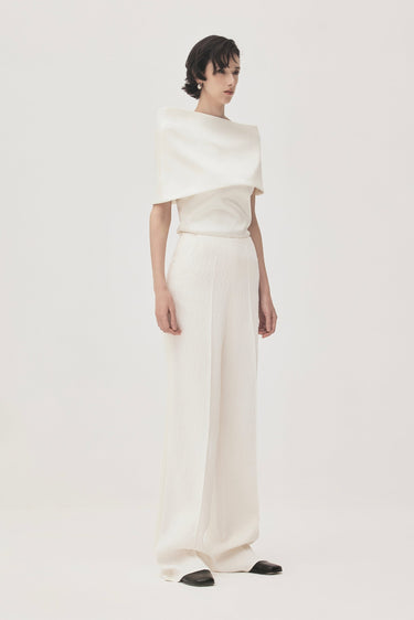 Woman wearing a white outfit on a plain background